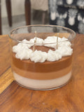 Handcrafted Wickory beeswax candle in a clear glass jar featuring layered caramel-brown and ivory wax, topped with piped white wax resembling whipped cream and multiple braided cotton wicks.