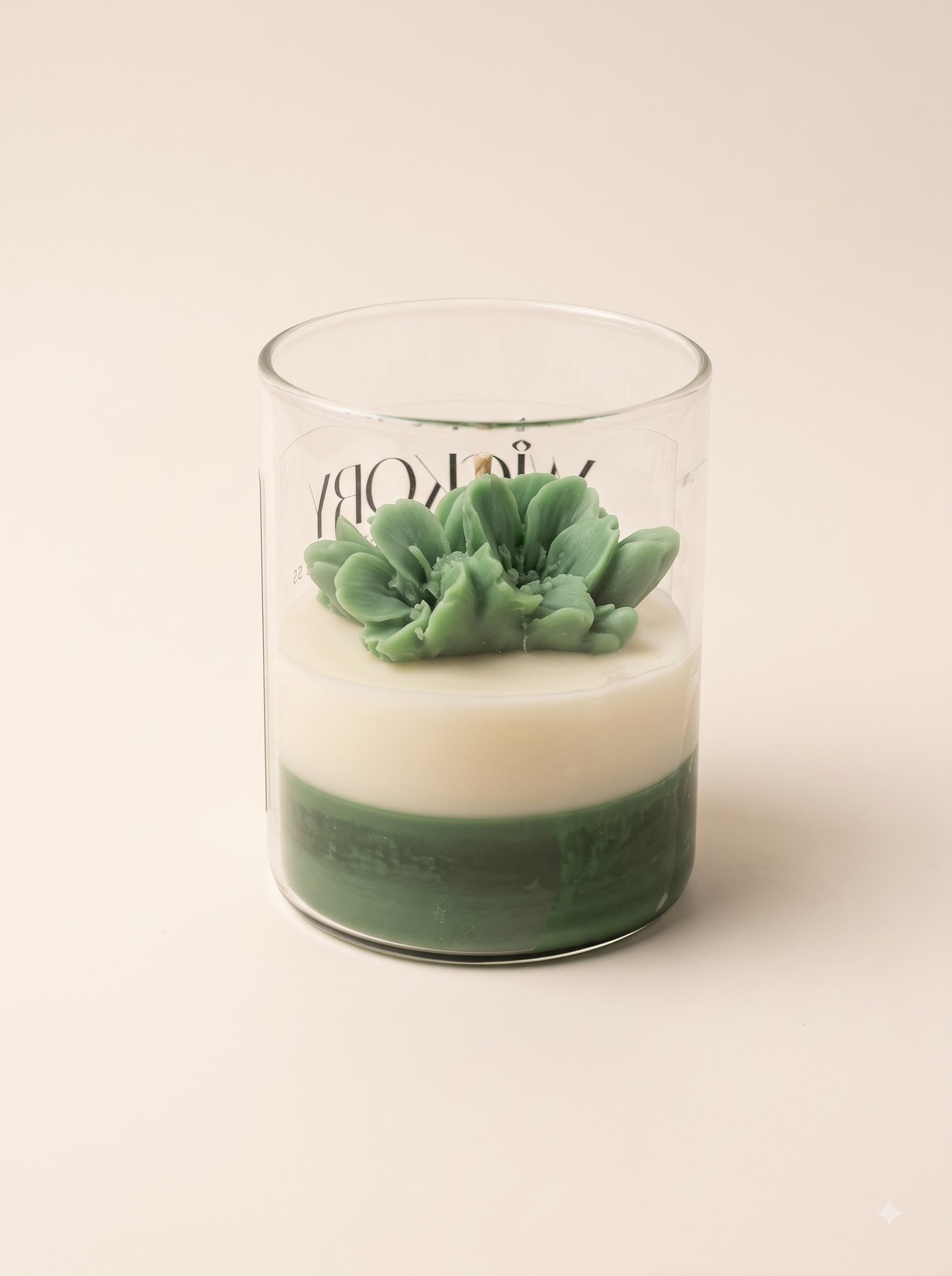 Five Wickory beeswax candles arranged on a wooden surface, featuring four small jars and one larger jar in the center, each with blush and ivory layered wax and sculpted floral tops in clear glass containers.