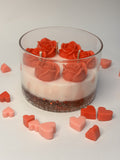 Layered beeswax candle in a clear borosilicate jar featuring a decorative gel base with suspended red shimmer, a smooth ivory wax layer, and six sculpted crimson rose-shaped blooms with cotton wicks, surrounded by small heart-shaped wax accents.
