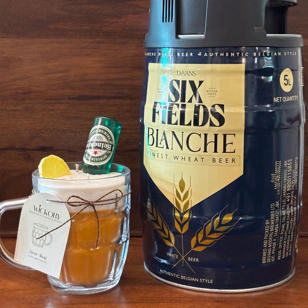 Beer Mug beeswax candle with a lemon slice, mini bottle and Wickory gift tag, next to a beer keg on a wooden table