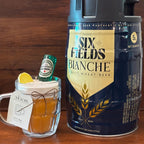 Beer Mug beeswax candle with a lemon slice, mini bottle and Wickory gift tag, next to a beer keg on a wooden table