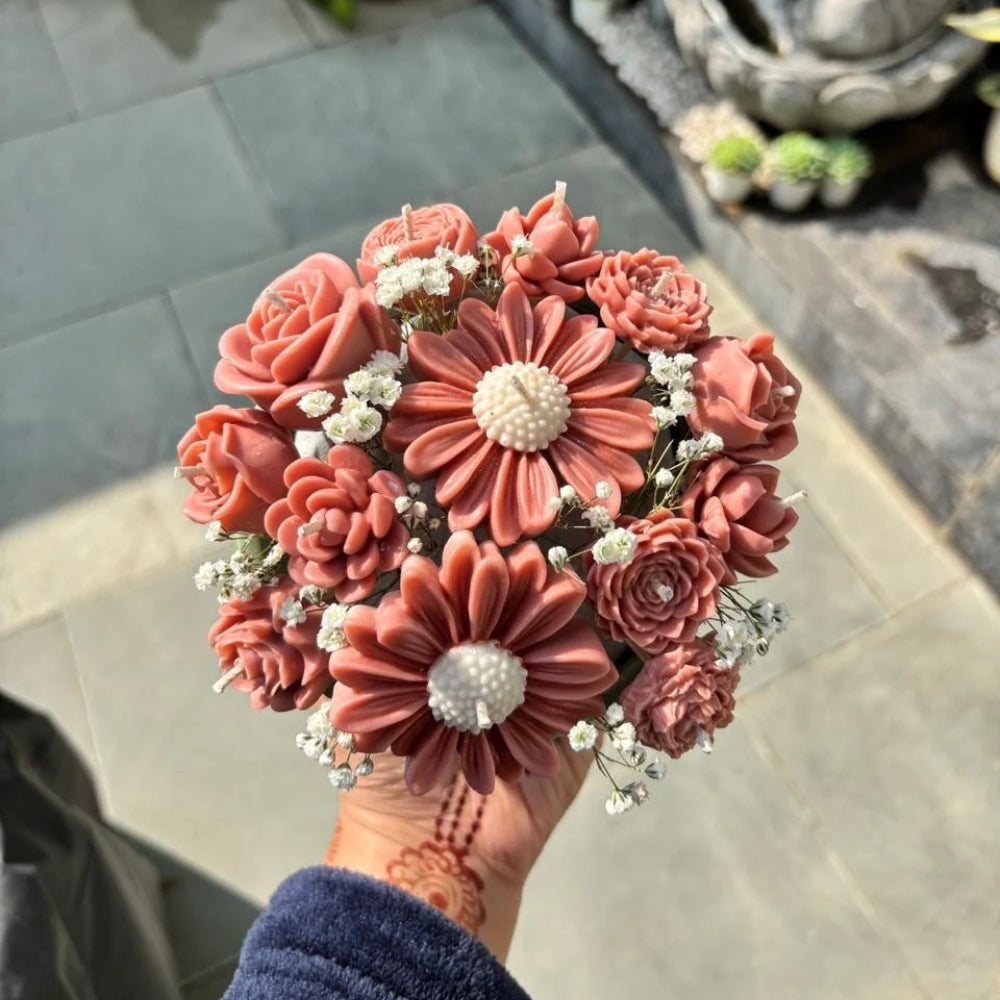 Wickory Blossom Posy held outdoors: dusty rose sculpted beeswax flower candles around a large daisy-style bloom