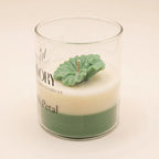 The Blush Petal in green: a sculpted green flower on ivory and green layered wax in a labelled glass jar