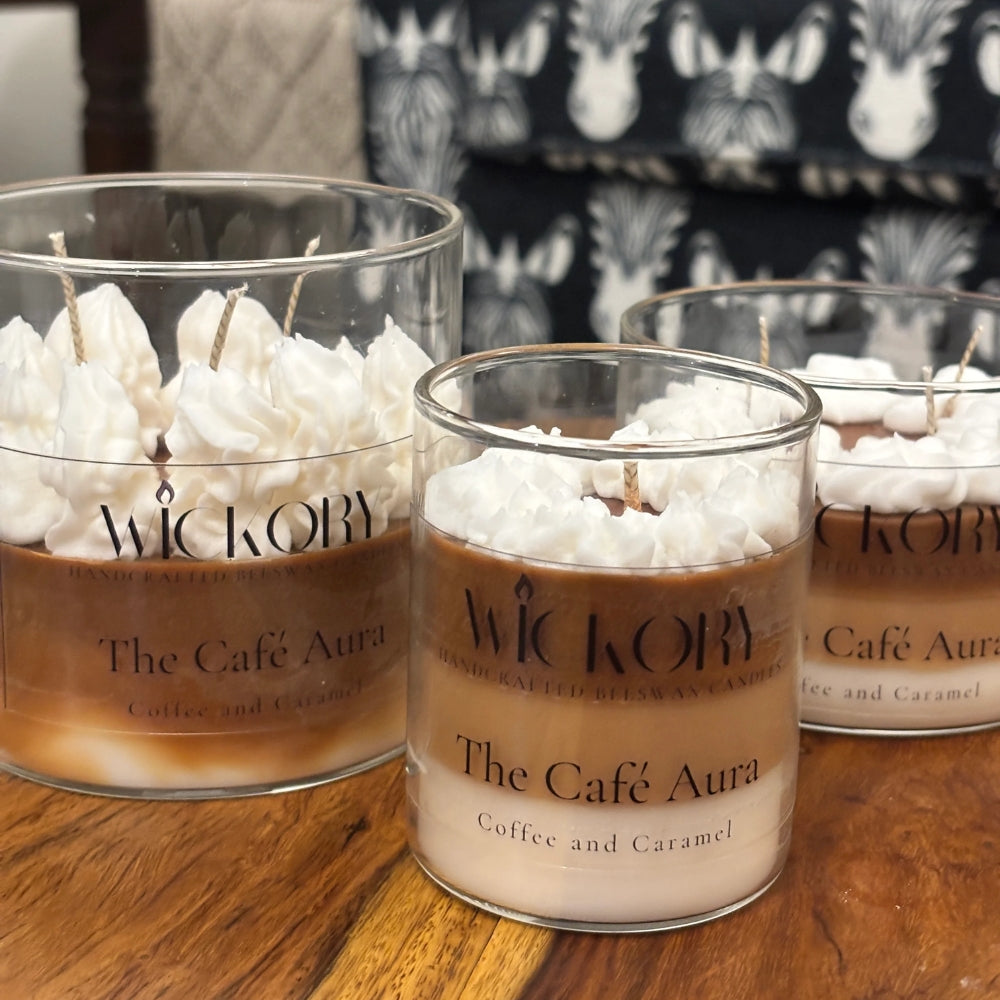 Three Café Aura candles in different sizes, each labelled and topped with whipped wax