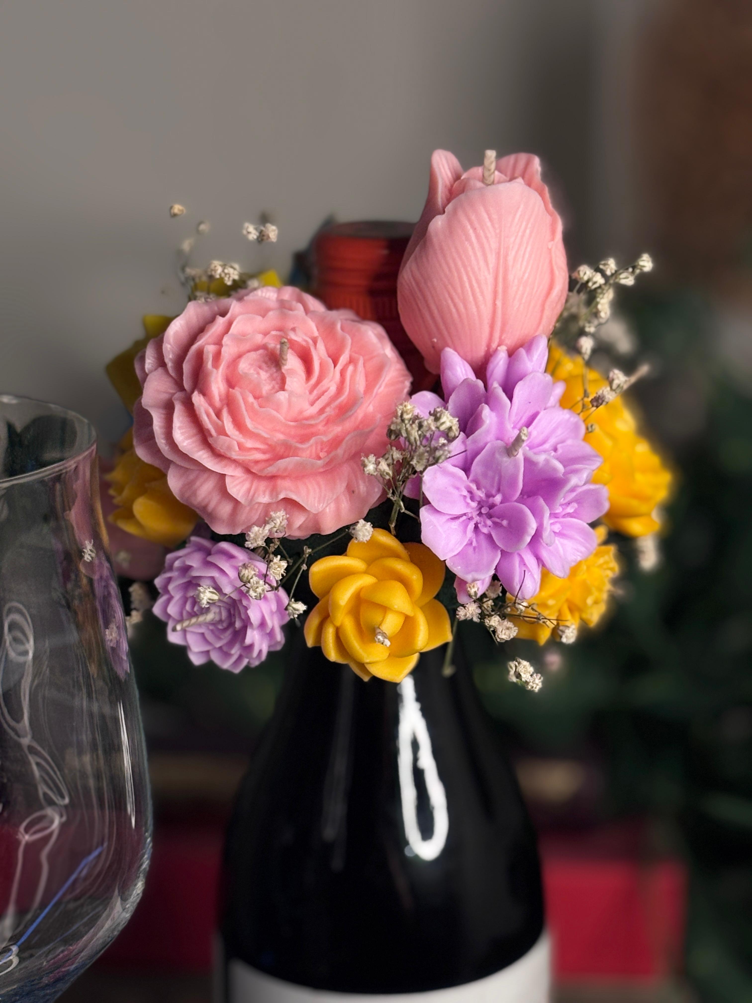 Wickory Cork and Bloom handcrafted beeswax floral candle topper placed over a wine bottle, featuring hand-poured florals in yellow — a unique luxury gift for wine lovers