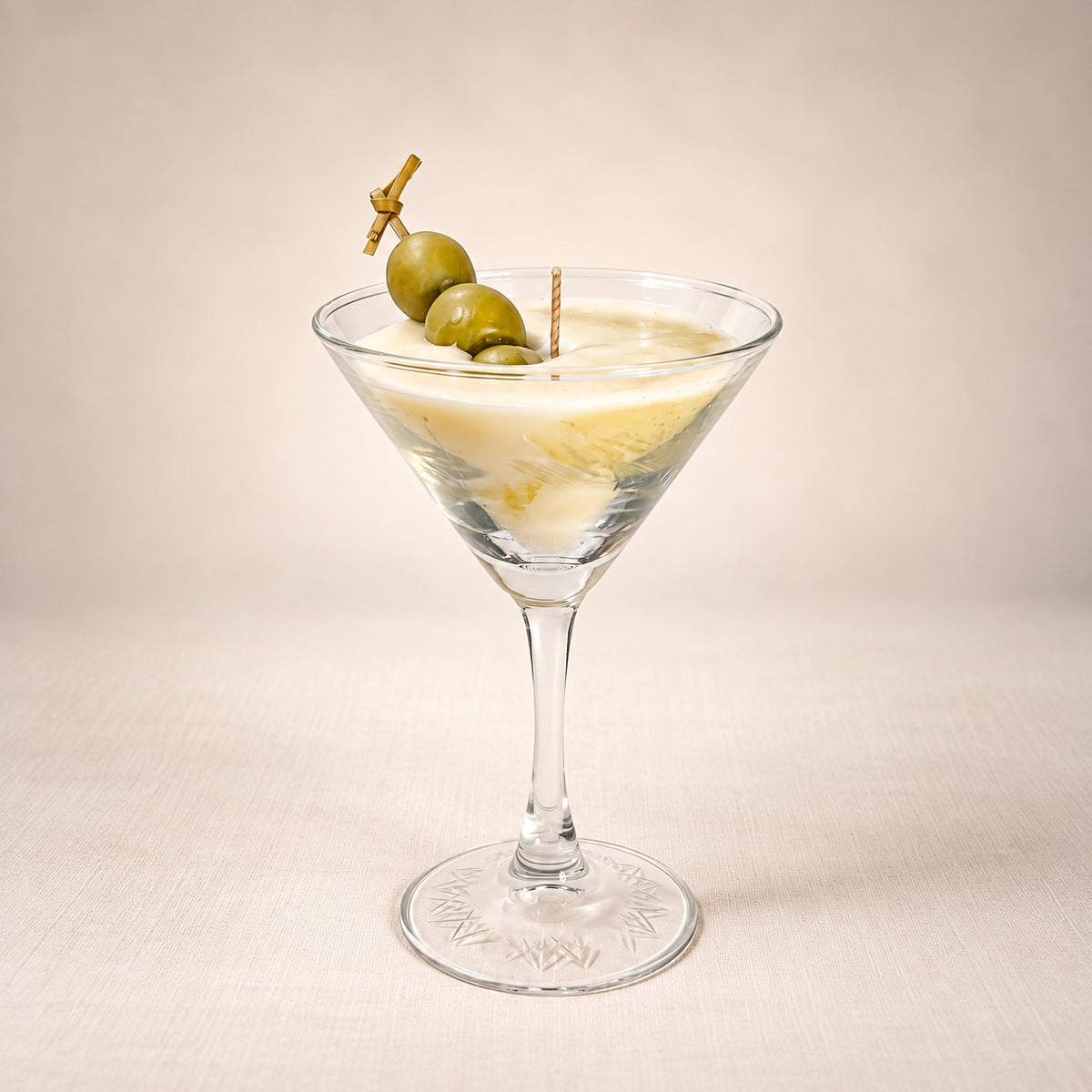 Dirty Martini beeswax candle: ivory wax in a martini glass with green olives on a skewer
