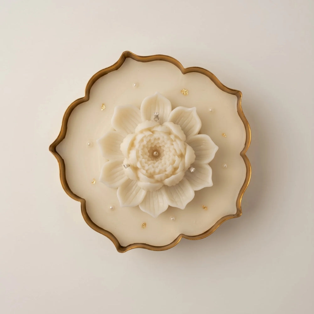 Close-up of the Glittering Urli with Lotus: a sculpted ivory lotus on beeswax flecked with gold flakes, in a gold-edged urli