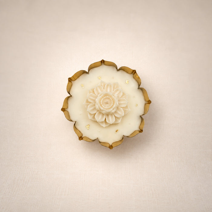 Glittering Urli with Lotus, top view: a gold-edged urli filled with ivory beeswax and crowned with a sculpted ivory lotus