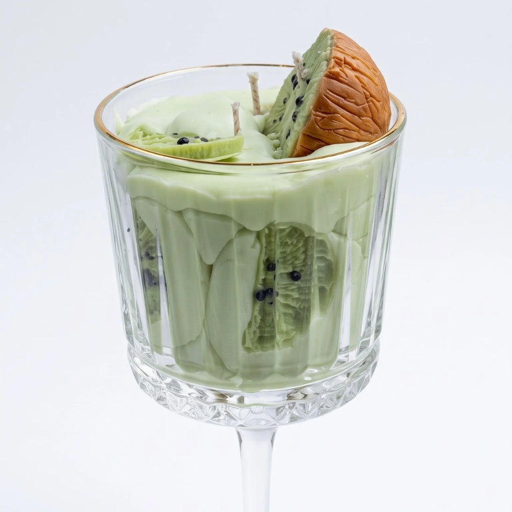Close-up of the Kiwi Colada candle: green wax with kiwi slices visible through the ribbed glass