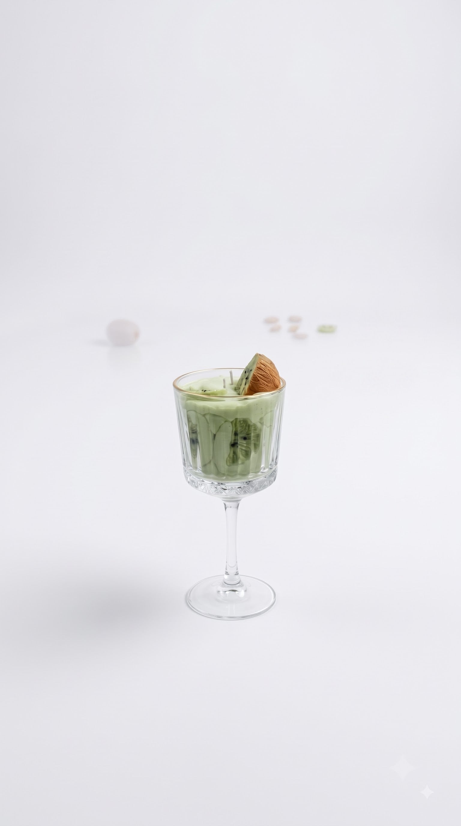 Wickory Kiwi Colada beeswax candle, soft green wax in a stemmed glass finished with hand-pressed kiwi slices and coconut detail