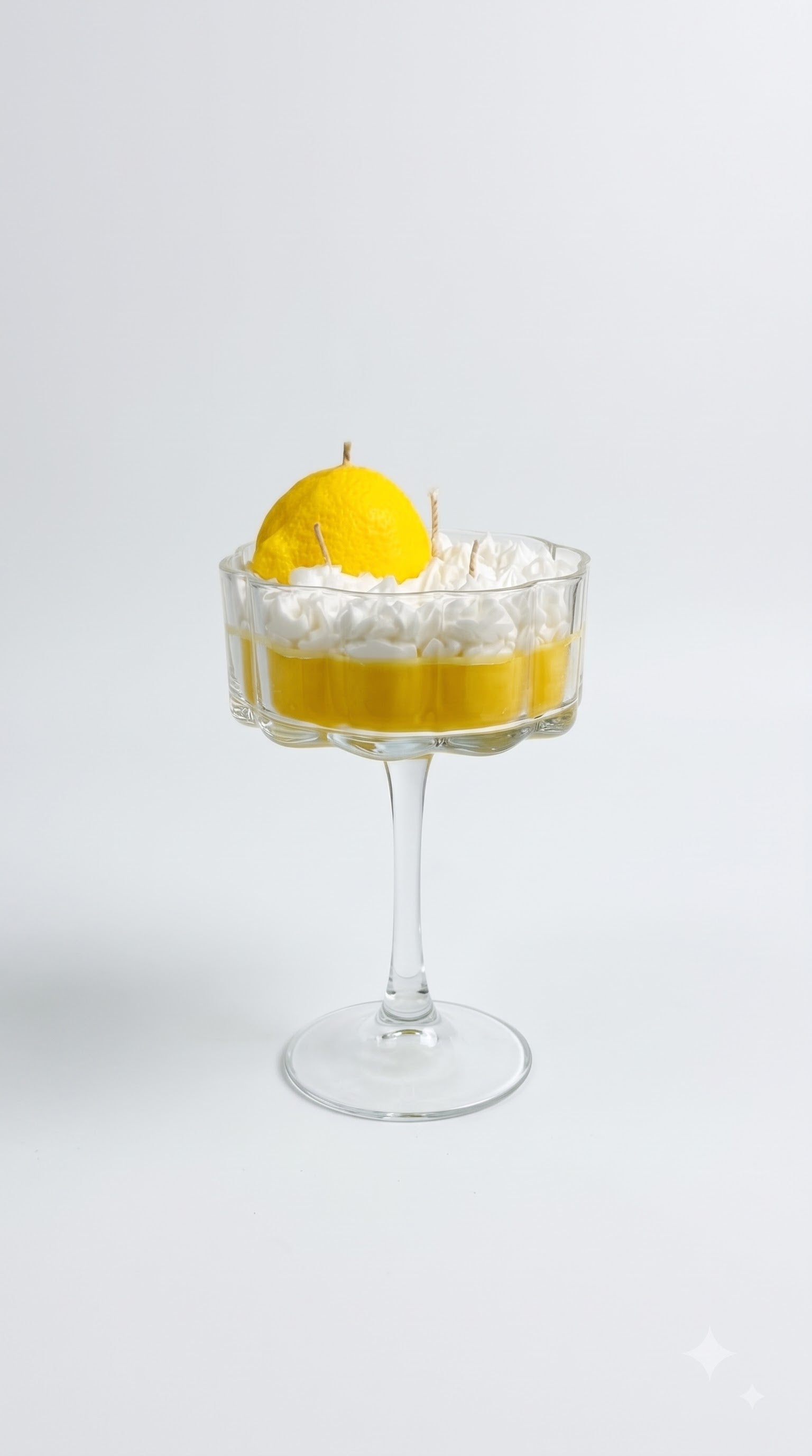 Wickory Limoncello beeswax candle, bright citrus-yellow wax in a coupe glass on a tall stem with a whipped top
