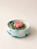 Lotus Deep: sculpted pink lotus with green leaves in a marbled teal and white lunite bowl