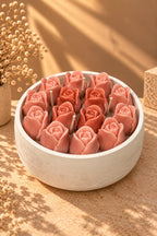 The Secret Garden in sunlight: sculpted pink rosebud candles packed into a white bowl